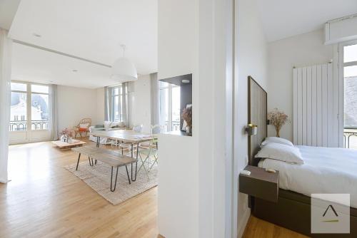a bedroom with a bed and a dining room with a table at Le Palais du Commerce in Rennes