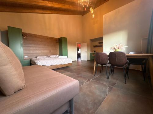 a bedroom with a bed and a table and chairs at Alpinia in Majdal Shams