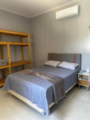 ein Schlafzimmer mit einem Bett, auf dem eine blaue Decke liegt in der Unterkunft DeckMC in Itarema