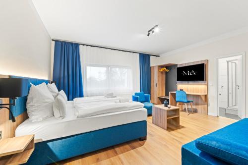 a bedroom with a large bed and a blue couch at Mivano Apartments - Allergarten in Celle