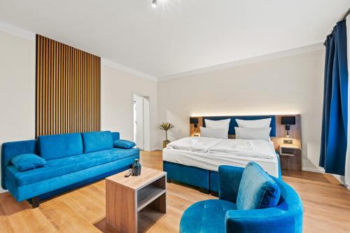 a bedroom with a blue couch and a bed at Mivano Apartments - Allergarten in Celle