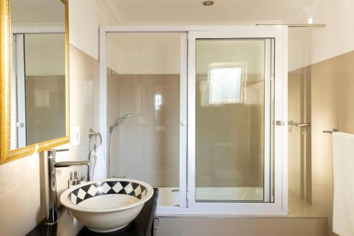 a bathroom with a glass shower and a sink at Dikalo Highston in Johannesburg