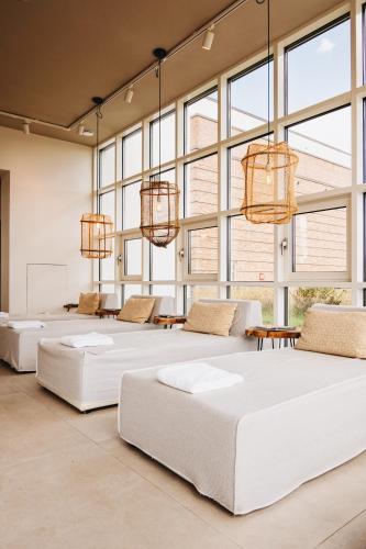a row of beds in a room with windows at Van der Valk Hotel Apeldoorn in Apeldoorn