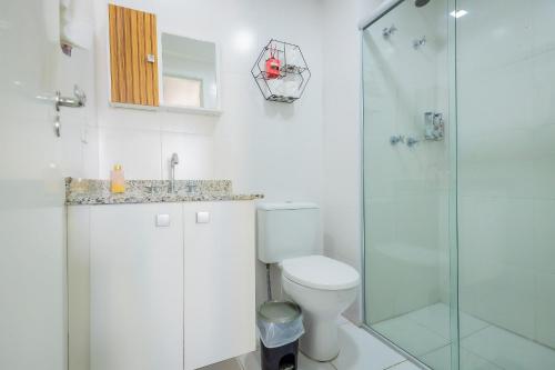 a bathroom with a toilet and a glass shower at 1506 - studio novo e completo in Guarulhos
