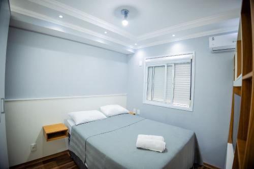 a white room with a bed and a window at 1506 - studio novo e completo in Guarulhos