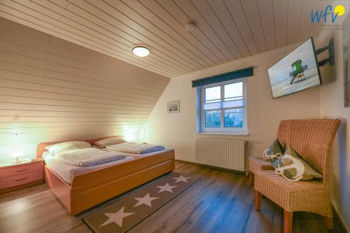 a bedroom with a bed and a chair in a room at Godenhus Ferienwohnung Mathis in Langeoog