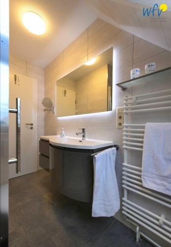 a bathroom with a large sink and a mirror at Godenhus Ferienwohnung Mathis in Langeoog