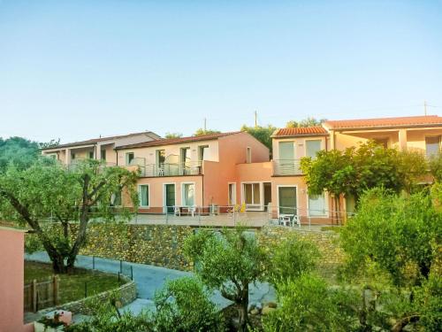 a row of houses with trees in the foreground at Apartment Borgoverde-5 by Interhome in Imperia