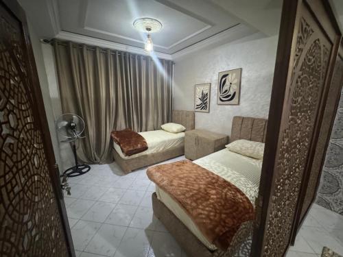 a bedroom with two beds and a lamp in it at Tranquility In the Center of Fez in Fez