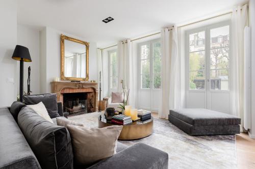 a living room with a couch and a fireplace at Les Jardins du Panthéon in Paris