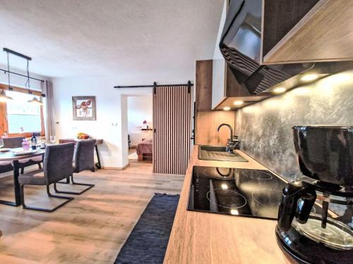 a kitchen with a stove and a dining room at Apartment August by Interhome in Schlitters