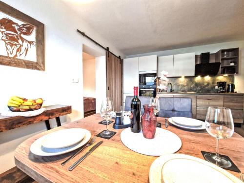 a wooden table with plates and wine glasses on it at Apartment August by Interhome in Schlitters