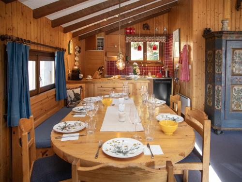 a wooden table with plates and glasses on it in a kitchen at Chalet 5 Ecorces by Interhome in Verbier