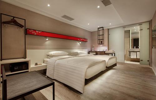 1 dormitorio con 1 cama blanca grande y escritorio en City Place Hotel, en Tainan