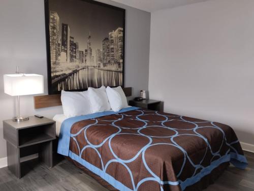 a hotel room with a bed and a lamp at Super 8 by Wyndham Morris in Morris