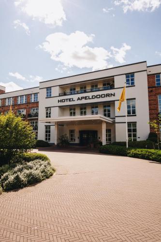 a building with a flag in front of it at Van der Valk Hotel Apeldoorn in Apeldoorn