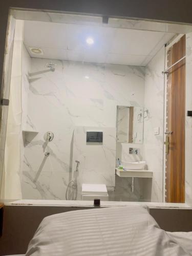 a white bathroom with a sink and a mirror at MADHUBAN STAYS rishikesh in Rishīkesh