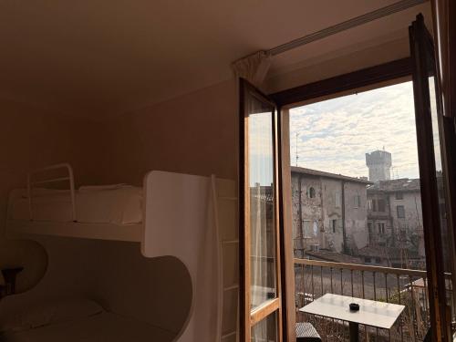 a bedroom with a bed and a balcony with a window at Hotel Corte Regina in Sirmione