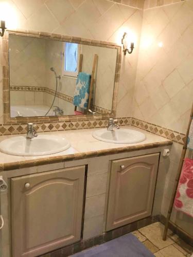 a bathroom with two sinks and a large mirror at Villa avec vue et piscine privée in Moltifao