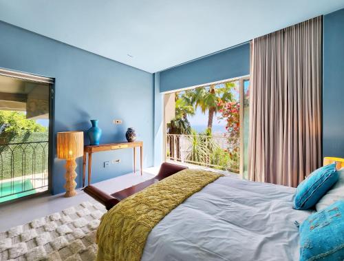 a bedroom with a bed and a large window at Luxury 8-Suite Villa with Heated Pools, Ocean & Mountain Views in Cape Town