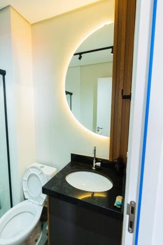 a bathroom with a sink and a toilet and a mirror at Studio Exclusivo in Cuiaba 1711 in Cuiabá