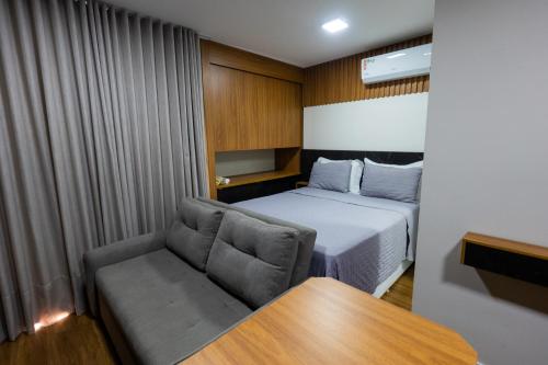 a small room with a bed and a couch at Studio Exclusivo in Cuiaba 1711 in Cuiabá