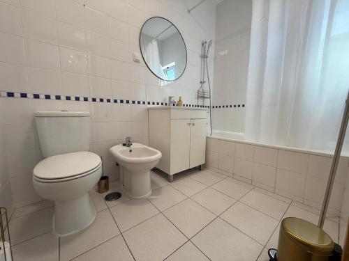 a bathroom with a toilet and a sink and a mirror at John Shelter in Portimão