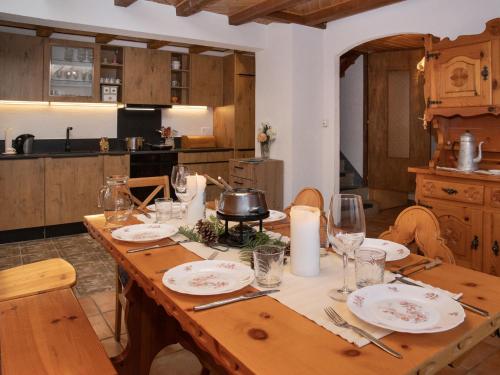 a kitchen with a wooden table with plates and glasses at Chalet Mélèze 1967 by Interhome in Ovronnaz