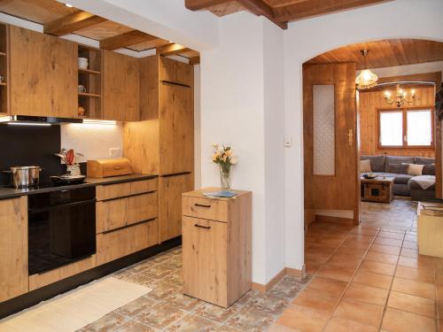 a kitchen with wooden cabinets and a living room at Chalet Mélèze 1967 by Interhome in Ovronnaz