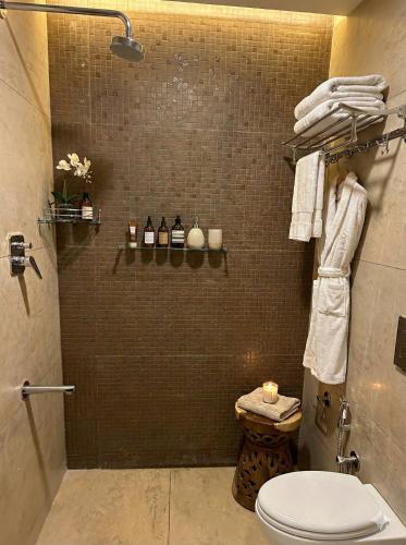 a bathroom with a toilet and a shower with towels at Hanuman Heritage in Chikmagalūr