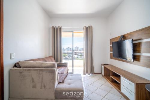 a living room with a couch and a flat screen tv at 1-Bedroom Apt in Floripa OAN0305 in Florianópolis