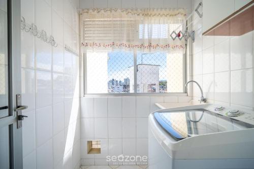 a white bathroom with a sink and a window at 1-Bedroom Apt in Floripa OAN0305 in Florianópolis