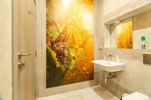 a bathroom with a painting of grapes and a sink at 1 BR Wine Journey in Sofia
