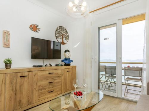 a living room with a tv and a glass table at Apartment Platja Mar by Interhome in L'Escala