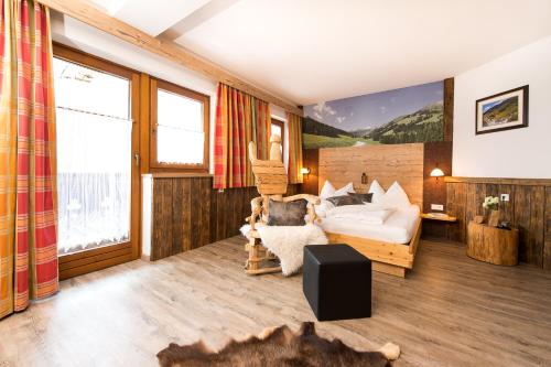 a living room with a bed and a couch at Hotel Astrid mit Panoramapool & inklusive JokerCard in Saalbach-Hinterglemm