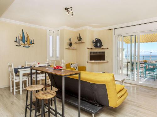 a living room with a table and a yellow couch at Apartment Xaloc by Interhome in Cubelles