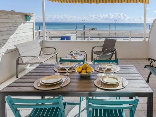 a table on the balcony with a view of the beach at Apartment Xaloc by Interhome in Cubelles