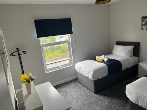 ein kleines Zimmer mit zwei Betten und einem Fenster in der Unterkunft Gemini 2 in Great Wyrley