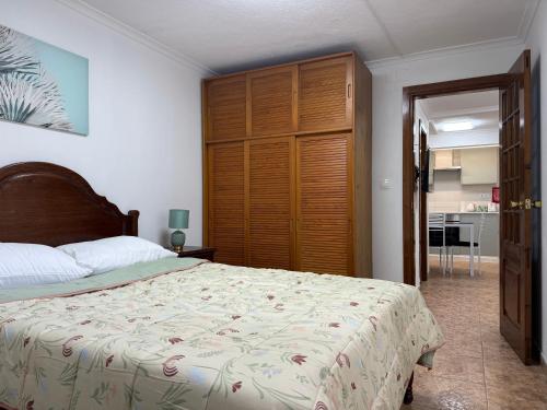 a bedroom with a bed and a large wooden closet at Apartamento Caminho da Praia in Pedro Miguel