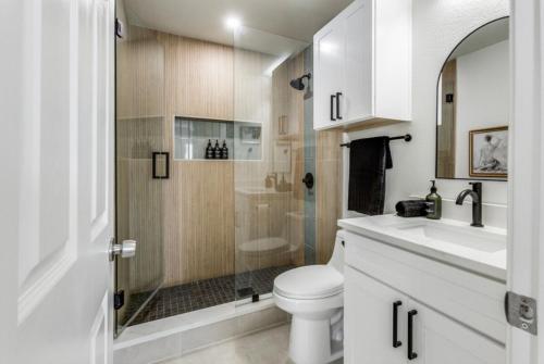 a bathroom with a shower and a toilet and a sink at Maison Noir Retreat 3B 2B KING in Richardson