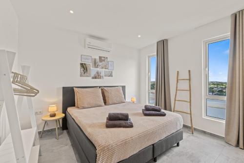 a bedroom with a bed with two pillows on it at Cura Kaat - Ruime 4 slaapkamer villa met zwembad op gated resort in Jan Thiel