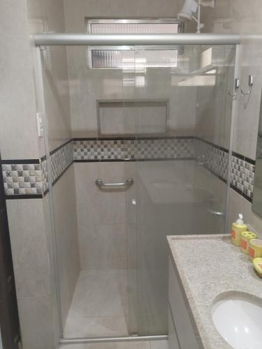 a glass shower in a bathroom with a sink at Bonito é ser Feliz Budget in Recife