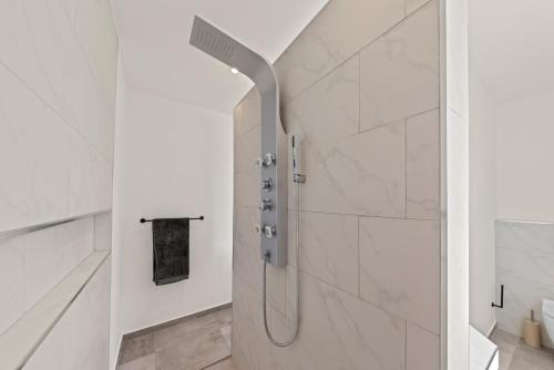 a shower with a glass door in a bathroom at Cura Kaat - Ruime 4 slaapkamer villa met zwembad op gated resort in Jan Thiel