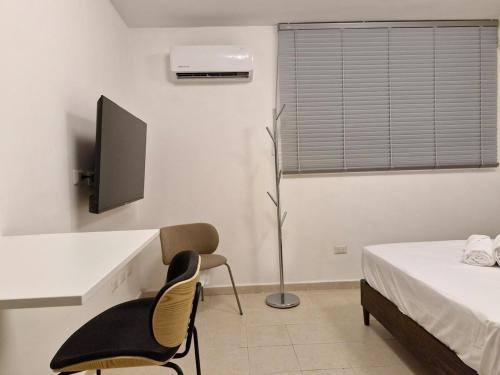 a bedroom with a bed and a desk and a chair at Loft 204 - H54 WAIWA HOST in Bucaramanga