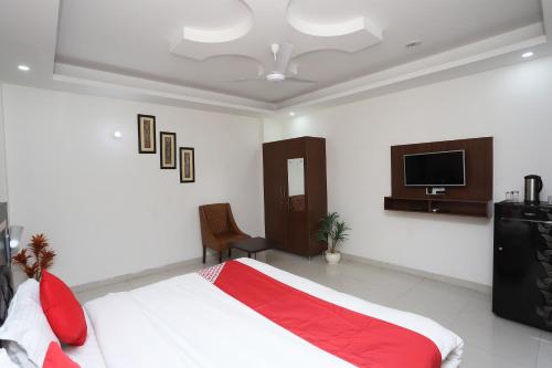 a bedroom with a bed and a flat screen tv at Capital O Levanti Near Aravali Biodiversity Park in Gurgaon