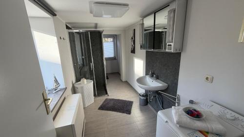 a white bathroom with a sink and a shower at Wohlfühlen am Großen Goitzschesee in Holzweißig