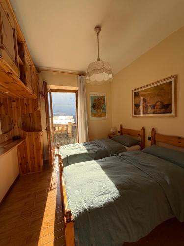 a bedroom with two beds and a large window at Ciasa Caligher in Venas