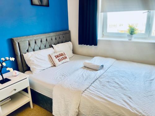 a bedroom with a white bed with a window at Urban Blue by Wolverhampton Train Station in Wolverhampton