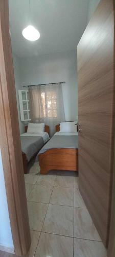 a small bedroom with two beds and a door at Skalia Mountain Sea Serenity in Kalymnos