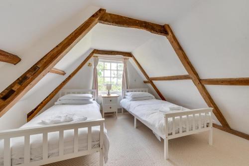 two beds in a attic bedroom with wooden beams at 4 Bed in Wangford oc-2tov in Wangford